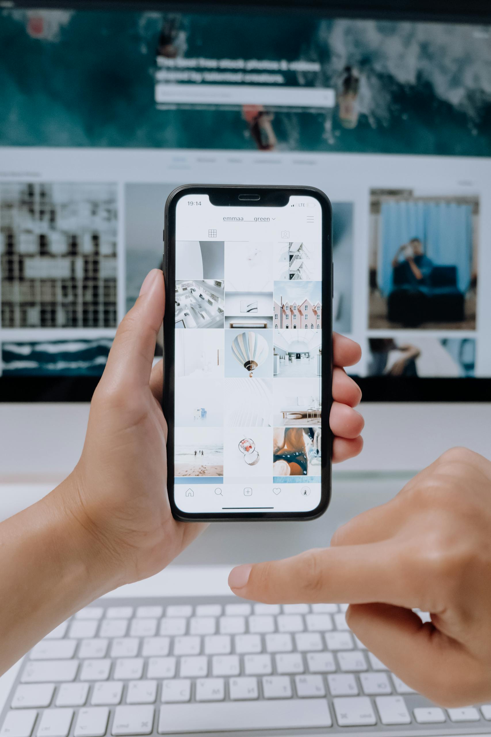 Social Media Marketing Services in Canada - Digital Agency 1 Person using smartphone to browse photos, office desktop setup.